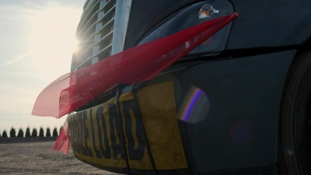 Oversize load banner and red flag on flatbed trailer. Close up shot