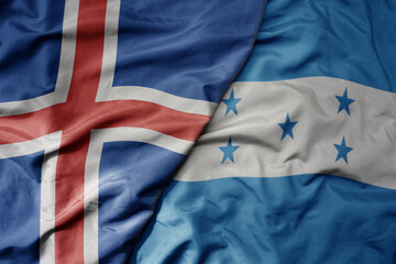 big waving national colorful flag of icelandic and national flag of honduras .
