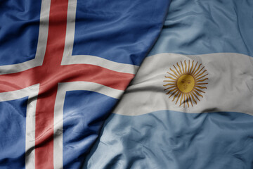 big waving national colorful flag of icelandic and national flag of argentina .