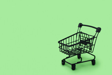 Small shopping cart on green background