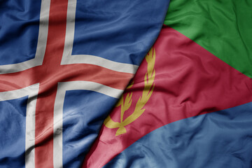 big waving national colorful flag of icelandic and national flag of eritrea .