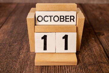 White block calendar present date 11 and month October on wood background