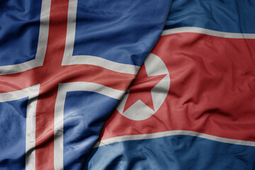 big waving national colorful flag of icelandic and national flag of north korea .
