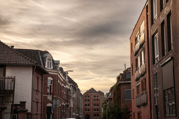 Fototapeta premium Modern residential buildings and flats in the city suburbs of Maastricht, Netherlands of red brick, in an modern street with residential buildings. It's a typical Dutch street at dusk.