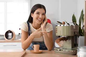 Young woman with coffee machine in kitchen