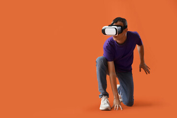 Naklejka premium Young man using VR glasses on red background