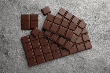 Delicious dark chocolate on grey table, flat lay