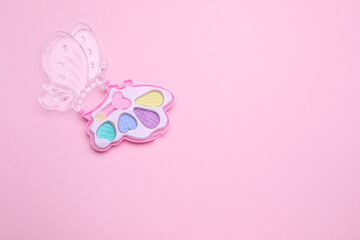 Decorative cosmetics for kids. Eye shadow palette on pink background, top view. Space for text