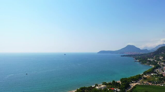 Coast of the Adriatic Sea in the city of Bar, Montenegro. Picturesque view of the urban terrain on the slopes of gorgeous green mountains. Aerial view.