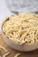 Bowl with uncooked Italian trofie pasta on table, closeup
