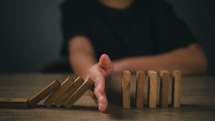 Hand-stopping domino effect. Concept of risk protection, business solution, or successful...