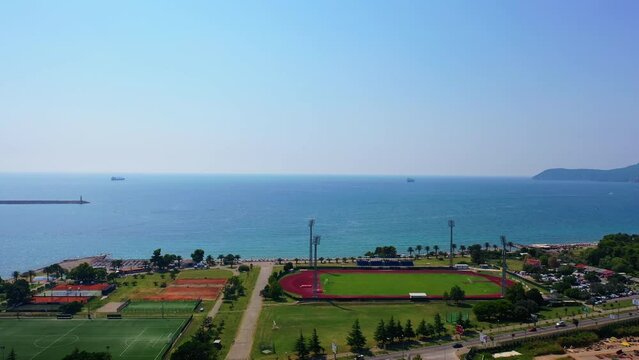 Approaching the beautiful waterscape of Adriatic Sea. Drone footage above the green area at the shore.
