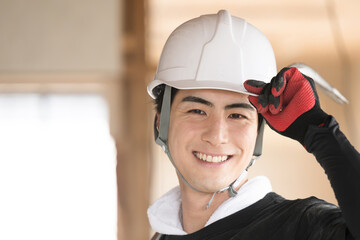 ヘルメットを被り作業着を着た男性のアップの笑顔