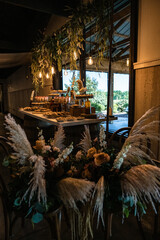Wedding reception dessert table with array of cakes and pies and cookies with pampas grass decor