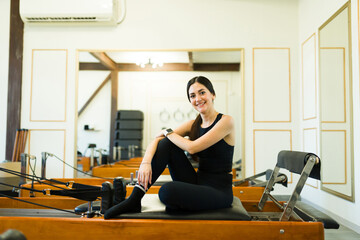 Happy young woman ready for her reformer bed pilates class