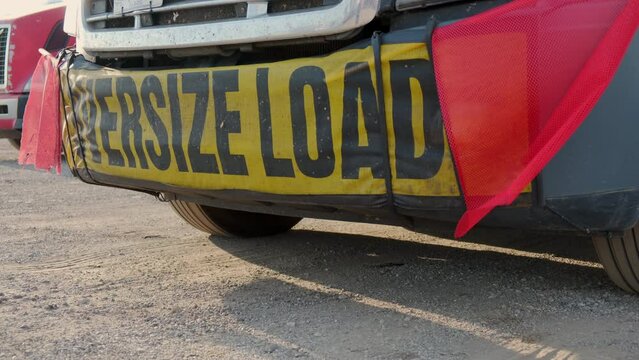 Oversize load banner and red flag on truck trailer. Close up shot
