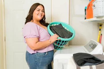 Photo sur Plexiglas Échelle de hauteur Attractive woman smiling doing her laundry and house chores