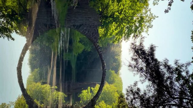 Devil's Bridge Rakotzbrucke in the Rhododendron Palace Landscape Park Kromlau, Lake Rakotz, Saxony, Germany, Vertical video. High quality 4k footage