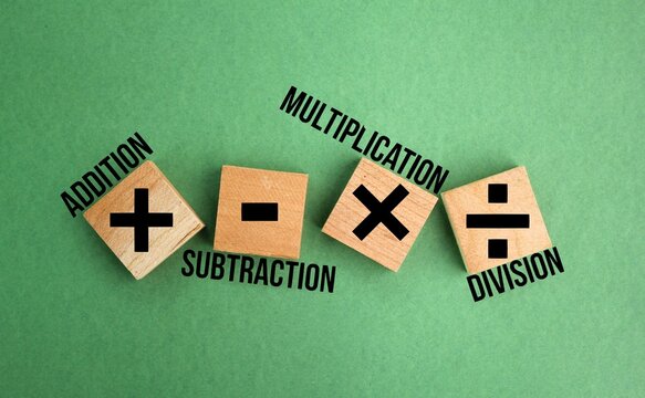 wooden squares with plus, minus, multiplication and division symbols. Four Basic Mathematical Operations. learning mathematics