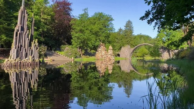 Devil's Bridge Rakotzbrucke in the Rhododendron Palace Landscape Park Kromlau, Lake Rakotz, Saxony, Germany. High quality 4k footage