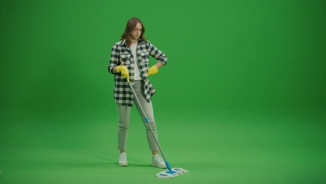 Green Screen.An Exhausted Young Woman Housewife in Yellow Rubber Gloves is Tired of Washing the Floor with a Mop.Cleaning for Pet Allergies and Sensitivities.