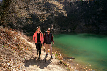 Young fit couple hiking together, enjoying beautiful sunny day 