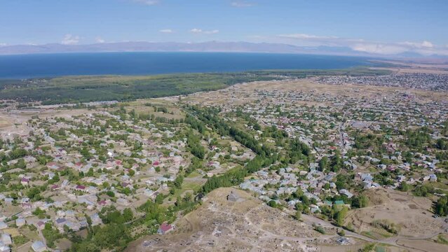 Forward reveal aerial shot of Nerkin Getashen and Martuni on sunny summer day. Gegharkunik Province, Armenia.