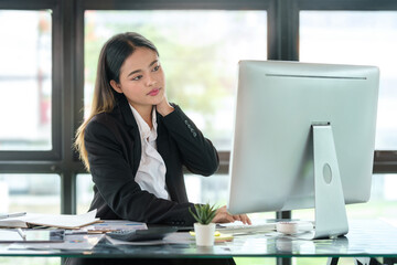 Overworked businesswoman suffering from neck and shoulder pain from incorrect posture.
