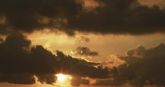 Clouds across golden sky morning time lapse sun peeking