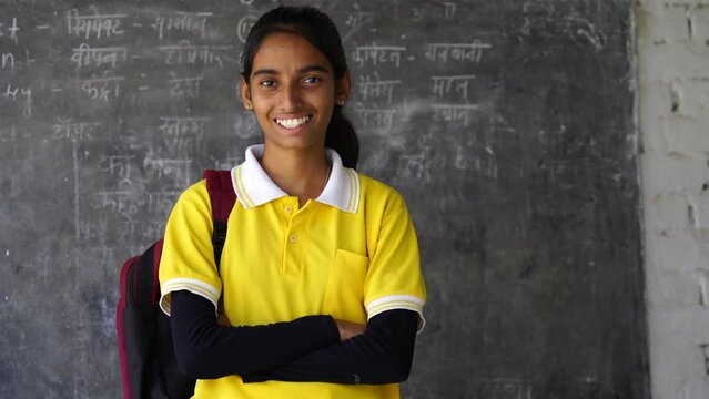Happy Rural Indian student schoolgirls wearing school uniform holding books and bag standing together, Studio shot, Education concept.