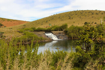 Scenic view of river, rocky mountains covered with green trees