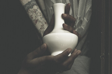 Woman hand holding a ceramic pot