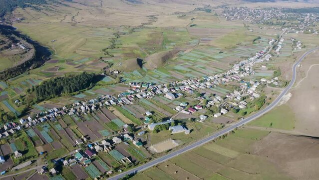 Forward reveal aerial shot of Fioletovo (Russian Molokans village) on sunny summer day. Lori Province, Armenia.