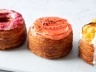 Assorted croissant donuts on a marble background