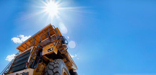 hero shot of a huge mining truck against the blue sky, design elements banner format