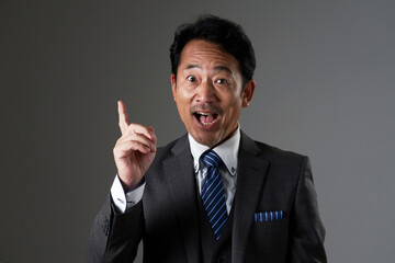 ひらめく中年のビジネスマン　黒背景