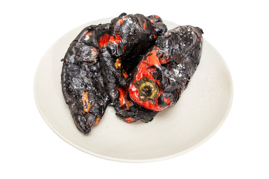 Roasted red kapia peppers on a gray ceramic plate isolated on white