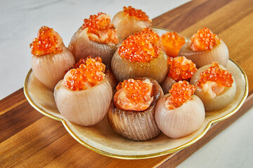 Shallots stuffed with meat and red caviar on plate