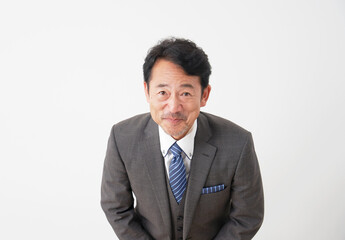 お辞儀する中年のビジネスマン　白背景