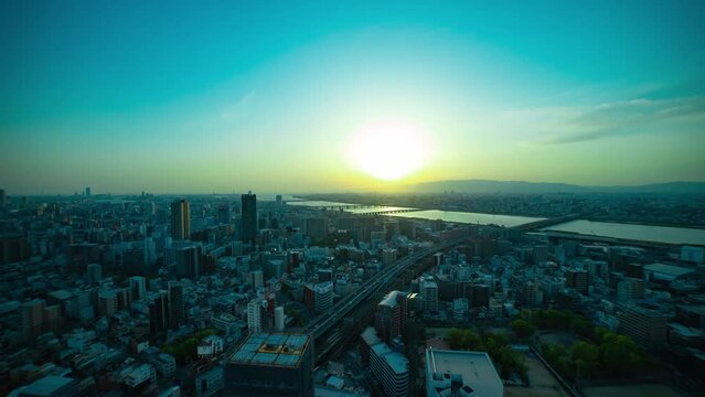 A sunset timelapse of panorama cityscape near Yodo river in Osaka wide shot tilt