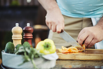 Unrecognizable man slicing sweet bell pepper for salad