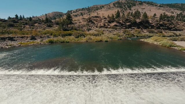 Water flowing over dam on truckee river in slow motion 