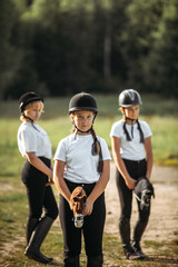 Fototapeta premium Portrait of a jockey girl who sits on a toy horse.