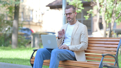 Online Video Chat by Middle Aged Man on Laptop Outdoor