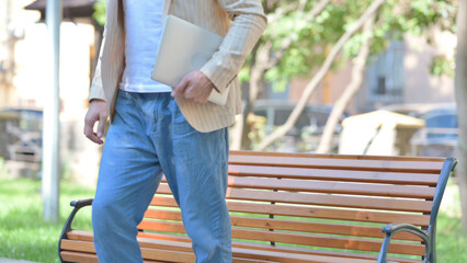 Middle Aged Man Leaving Bench Outdoor after Working on Laptop