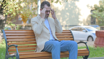Fototapeta premium Modern Casual Man Sitting Outdoor with Headache