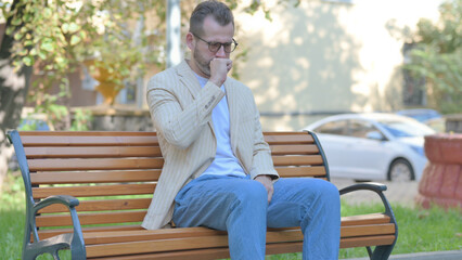 Fototapeta premium Coughing Modern Casual Man Sitting Outdoor