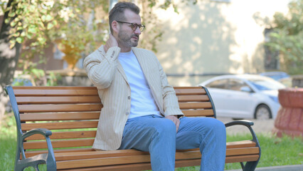 Modern Casual Man Sitting Outdoor with Neck Pain