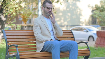Fototapeta premium Modern Casual Man with Toothache Sitting Outdoor