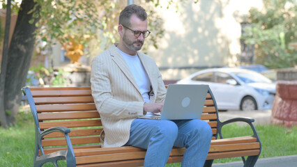 Fototapeta premium Modern Casual Man Working on Laptop Outdoor